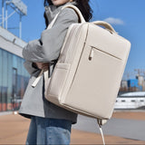 Femme portant le sac à dos ordinateur portable beige en ville