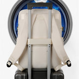 Sac à dos cabine femme fixé sur une valise avec la sangle trolley